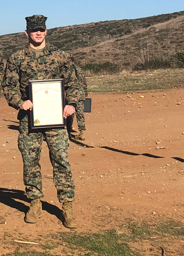 Kyle E. Hiner in military combat uniform holding an award